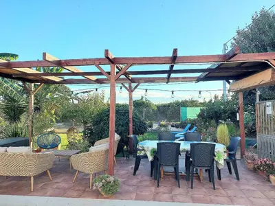 a wooden pergola with a table and chairs at Ca Emma in Mahuella