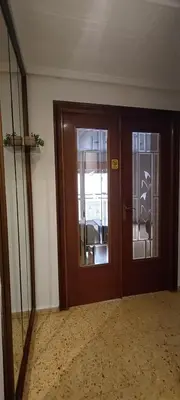 a room with a wooden door and a glass doorway at Piso Colon in Paiporta