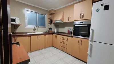 a kitchen with wooden cabinets and a white refrigerator at Piso Colon in Paiporta