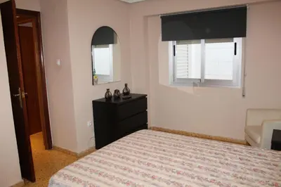 a bedroom with a bed and a dresser and a mirror at Piso Colon in Paiporta