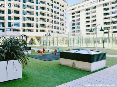 a courtyard in a building with a playground with buildings at Sabbia Valencia Apartment in Valencia