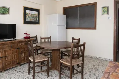 a dining room with a table and chairs and a refrigerator at Apolo, 5º- 30 in Cullera