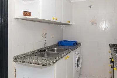 a kitchen with a sink and a washing machine at Dosel, 6º-30 in Cullera