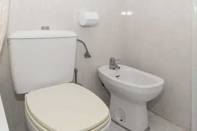 a bathroom with a white toilet and a sink at Dosel, 6º-30 in Cullera