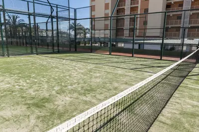 a tennis court with a net in front of a building at Florazar 1, Iii-B 8-B in Cullera