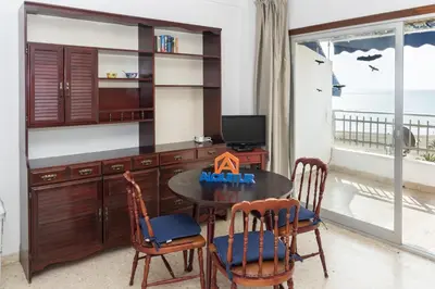a dining room with a table and chairs and a television at Florazar 1, Iii-B 8-B in Cullera