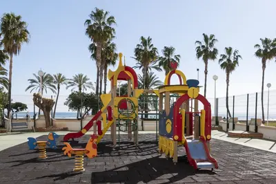 a playground at a park with palm trees at Florazar 1, Iii-B 8-B in Cullera