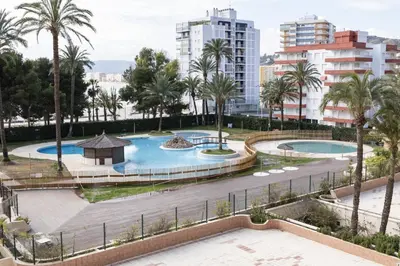 a view of two pools with palm trees and buildings at Florazar 2, Vi-11-C in Faro de Cullera