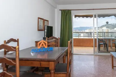 a dining room with a table and a balcony at Florazar 2, Vi-11-C in Faro de Cullera