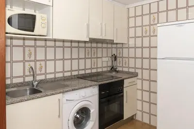 a kitchen with a washer and a sink and a microwave at Florazar 2, Vi-11-C in Faro de Cullera