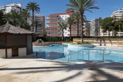 a large swimming pool with palm trees and buildings at Florazar 2, Vi-13-C in Faro de Cullera