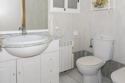 a white bathroom with a sink and a toilet at Frontalmar, Esc-A, 8º-29 in Cullera