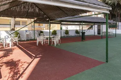 a patio with white tables and chairs under a roof at Las Vegas, Esc-3, 7º-19 in Cullera