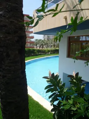 a swimming pool next to a building with a tree at Las Vegas, Esc-3, 7º-19 in Cullera