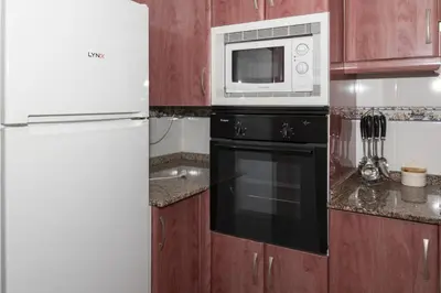 a kitchen with a microwave and a refrigerator at Lider, 10-B in Cullera