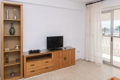 a living room with a television on a wooden cabinet at Lider, 2-G in Cullera
