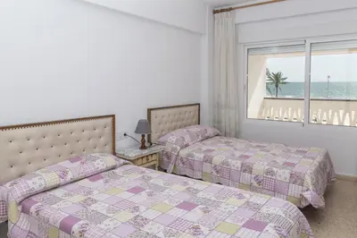 two beds in a bedroom with a view of the ocean at Lider, 2-G in Cullera