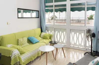 a living room with a green couch and a window at Lider, 44-E (Planta Baja) in Cullera