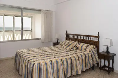 a bedroom with a bed with a view of the ocean at Lider, 5-C in Cullera
