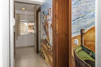 a hallway with a large painting on the wall at Lider, 8-A in Cullera