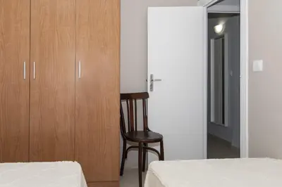 a bedroom with a chair next to a wooden cabinet at Mar Y Montaña 7º-119 in Cullera