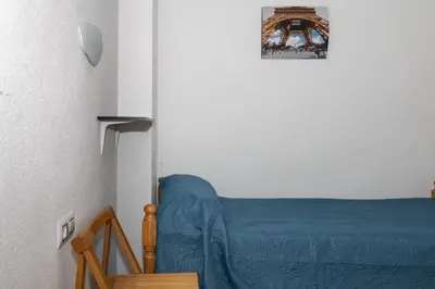 a bedroom with a bed with a blue blanket at Miralmar, 10º-69 in Cullera