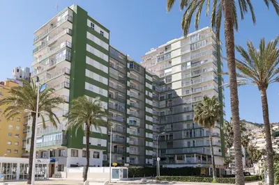a tall building with palm trees in front of it at Montemar, B-9º-26 in Cullera