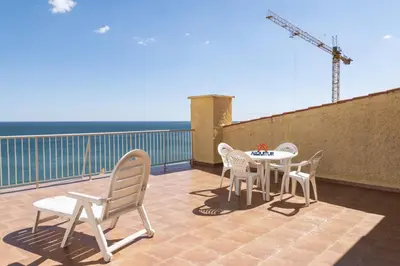 a patio with a table and chairs on a balcony at Pleno Sol, 45 in Cullera