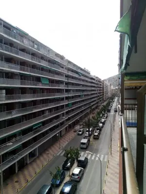 a large building with cars parked outside of it at Provence, 5º-18 in Cullera
