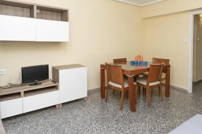 a dining room with a table and chairs and a tv at Provence, 5º-18 in Cullera