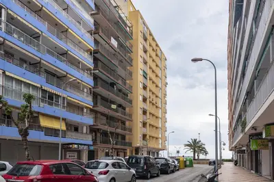 a street with cars parked in front of buildings at Provence, 7º-25 in Cullera