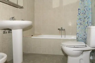 a bathroom with a toilet and a sink and a bath tub at Santa Marta, Iii-A 7º-16 in Cullera
