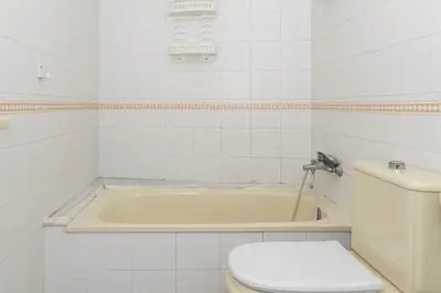 a bathroom with a toilet and a bath tub at Seniades, 6º-16 in Cullera
