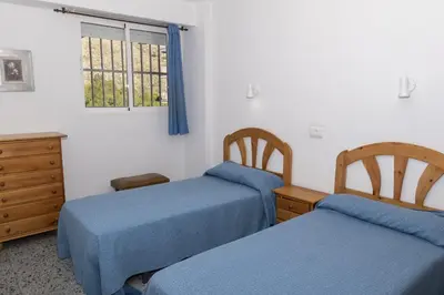 a bedroom with two beds and a dresser and a window at Trianon, 5º-29 in Cullera
