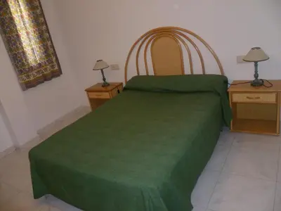 a bedroom with a green bed with two night stands at Villas Cap Blanc Ii, Pta 11 in Cullera