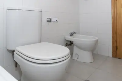 a bathroom with a white toilet and a sink at Villas Cap Blanc, 1-31 Cab I-36 in Cullera