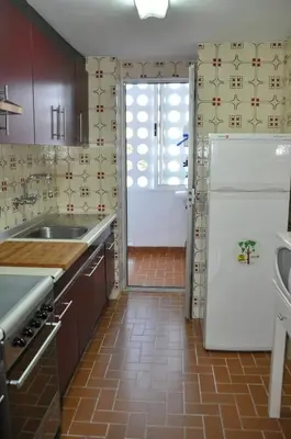 a kitchen with a sink and a refrigerator at Palm Tree Cullera in Cullera