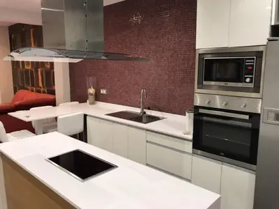 a kitchen with a sink and a stove top oven at Apartamentos BARRACA in Valencia