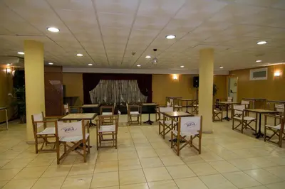 a dining room with tables and chairs and a couch at Portocanet Complejo Turístico in Canet de Berenguer
