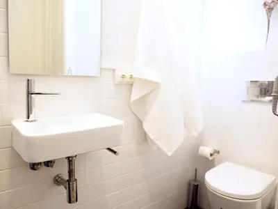 a white bathroom with a sink and a toilet at City Hall Correos in Valencia