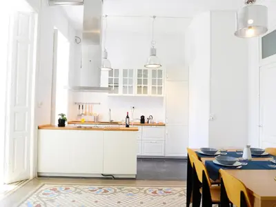 a kitchen with white cabinets and a table with chairs at City Hall Correos in Valencia