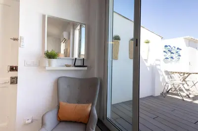a chair sitting on a balcony next to a sliding glass door at FLORIT FLATS - Ruzafa Attic with Private Terrace in Valencia