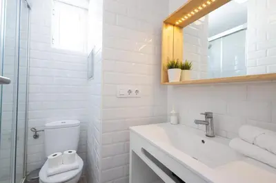 a white bathroom with a toilet and a sink at FLORIT FLATS - Ruzafa Attic with Private Terrace in Valencia