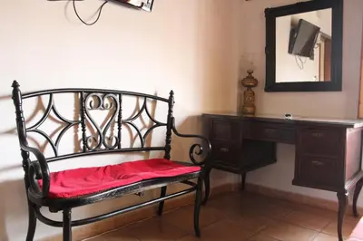 a chair with a red pillow sitting next to a desk at Hotel La Villa in Requena