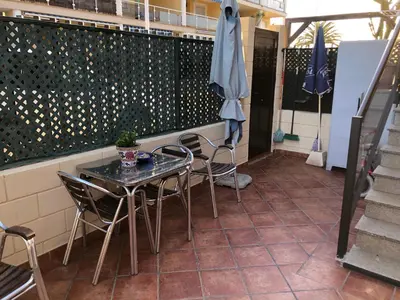 a patio with a table and chairs and a fence at Apartamento junto al mar Los Marineros con acceso independiente por terraza in Puzol