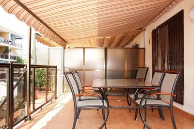 a dining room with a table and chairs on a balcony at Apartamento junto al mar Los Marineros con acceso independiente por terraza in Puzol