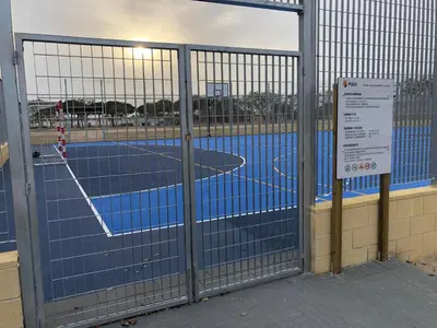 a tennis court behind a gate with a tennis court at Apartamento junto al mar Los Marineros con acceso independiente por terraza in Puzol
