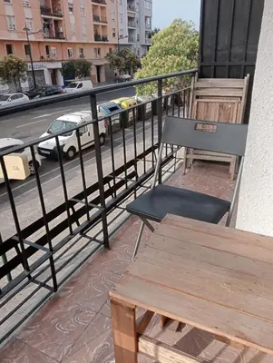 a table and chair on a balcony with a street at Apartamento La Marina Real in Valencia