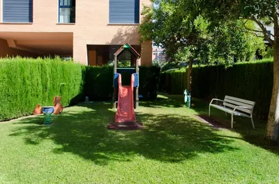 a playground in a yard next to a bench at ApartUP Francia Views in Valencia