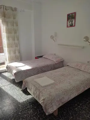 a room with three beds and a window at Apartamento Cuatro Carreres in Valencia